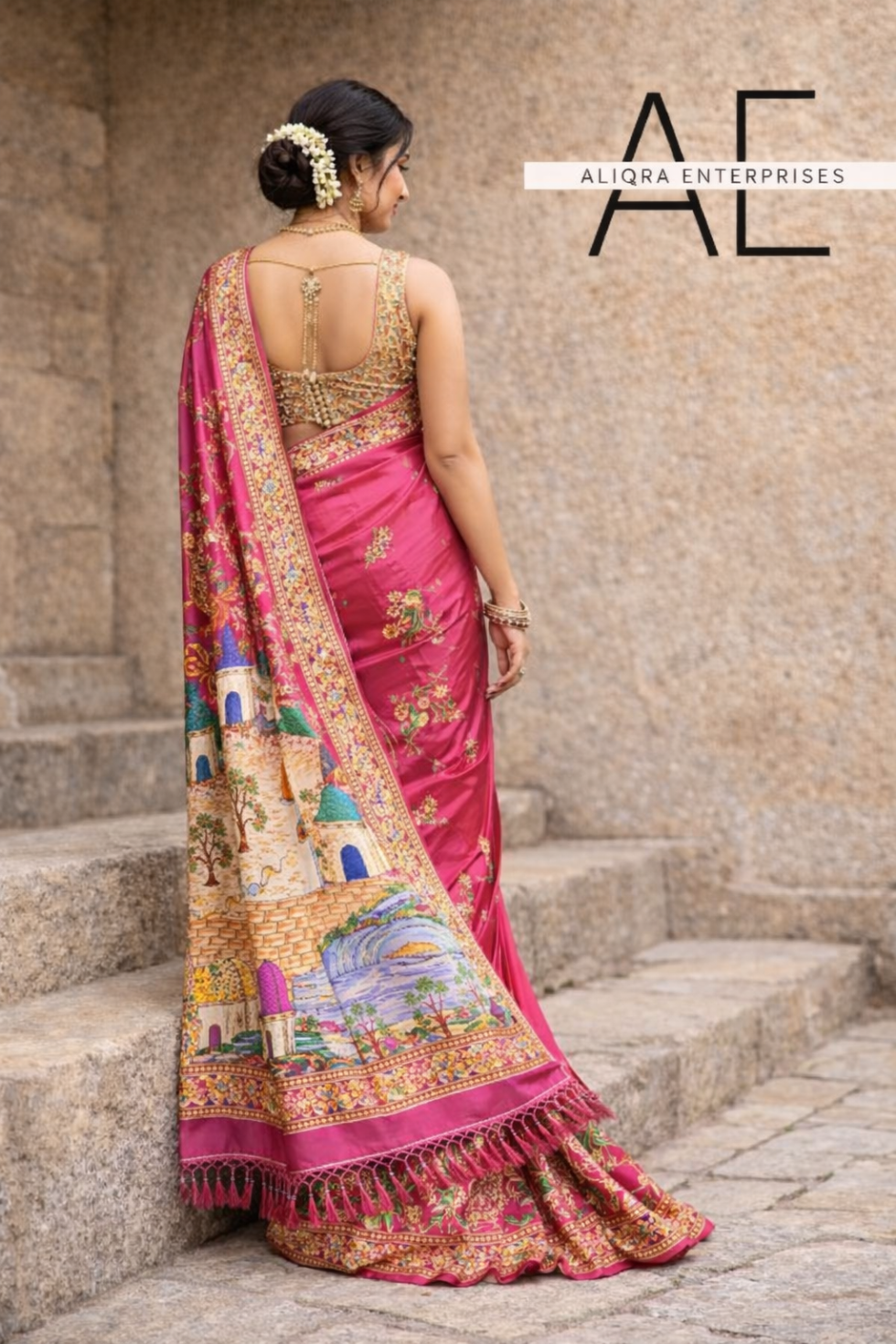 Back view of pink art silk saree showcasing embroidered blouse and heritage pallu artwork